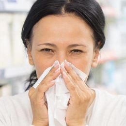 woman wiping nose with tissue