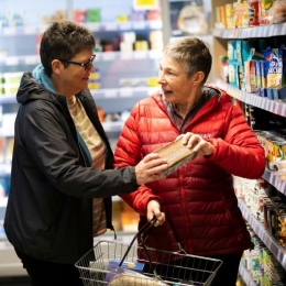 Older couple shopping together, reading food labels