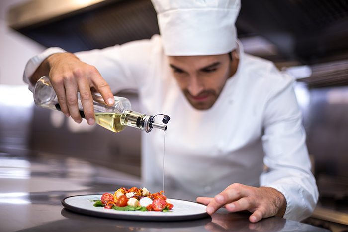 chef pouring oil