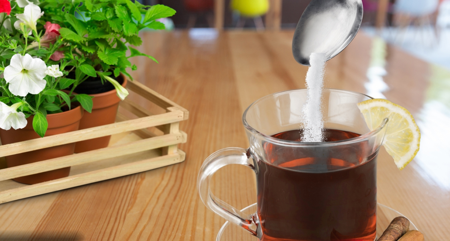 sweetener being spooned into tea