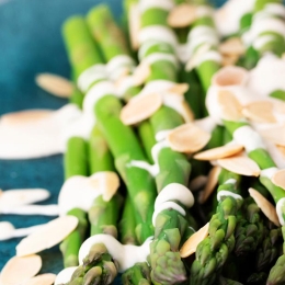 asparagus with almonds and sauce on plate