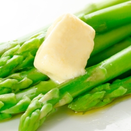 green asparagus stalks with melting pat of butter 