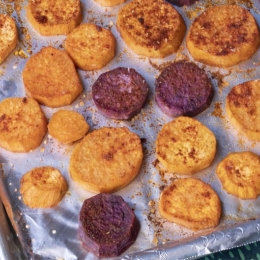 baking tray with sliced sweet potatoes covered in spices
