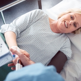 woman laying on hospital bed looking up at technician