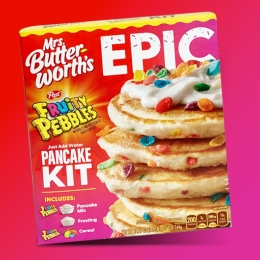 box of Epic Fruity Pebble pancake mix on red and pink background