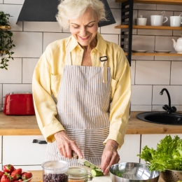 Older woman chopping vegetables in kitchen