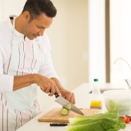 man chopping vegetables in bright kitchen