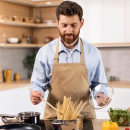 a man cooking pasta in a kitchen