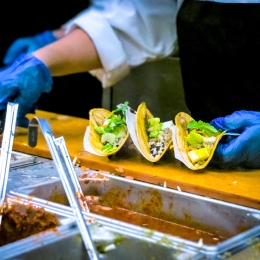 School cafeteria worker serving tacos to student