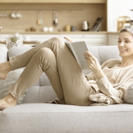 woman lounging and reading on a couch