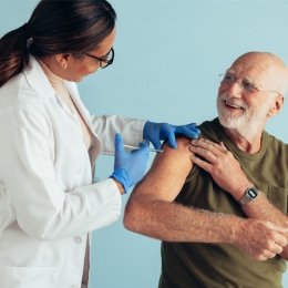 doctor giving an older man a vaccine in his arm