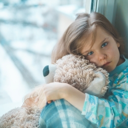 Hospitalized child hugging a teddy bear