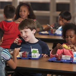 Children eating healthy foods in a school cafeteria