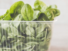spinach leaves in clear plastic carton