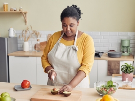 Woman cutting an avocado in bright kitchen