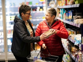 Older couple shopping together, reading food labels