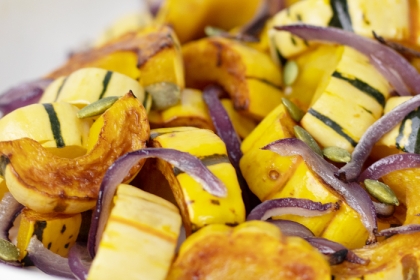 sliced delicata squash roasted and topped with sliced onions