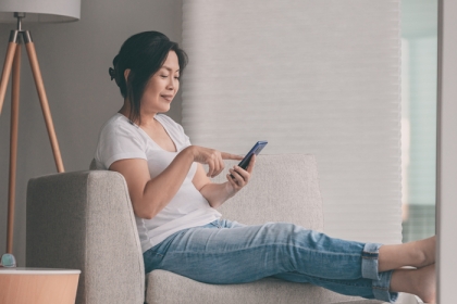 an inactive woman sitting and using her cellphone