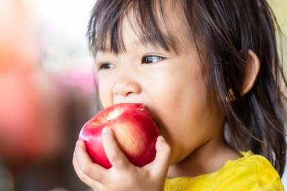 child eating an apple
