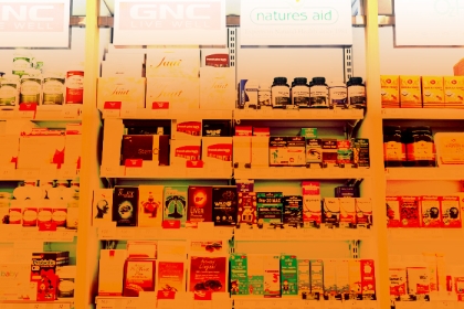 image of supplements on store shelves with an orange hue