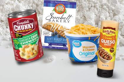 Canned soup, boxed mac & cheese, breakfast bars, and queso--packaged foods containing titanium dioxide--against a background of the powdered white substance.