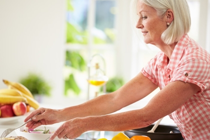 older woman prepping food in a kitchen