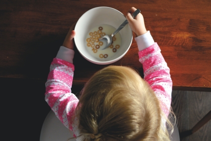 A child eating the last of her cereal.