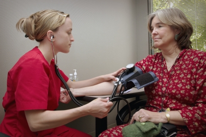 A medical professional taking the blood pressure of her patient.