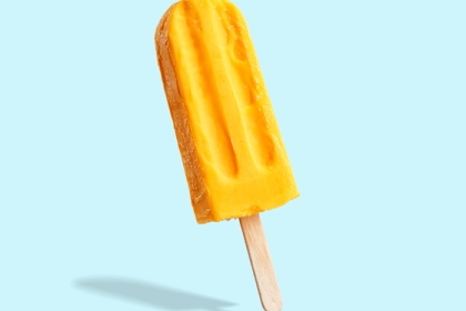 yellow popsicle on light blue background 