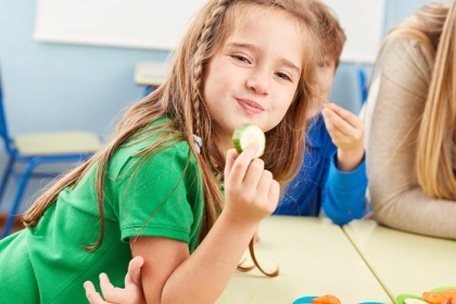 a girl enjoying a healthy snack at school