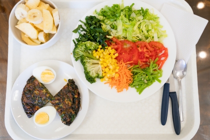 Vegetable salad, spinach omelette and fruit on tray