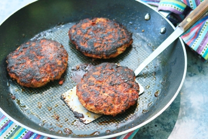 pan with three cooked chicken burger
