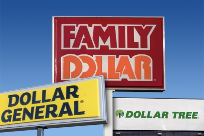 Signs for Dollar General, Family Dollar, and Dollar Tree with a blue sky in the background