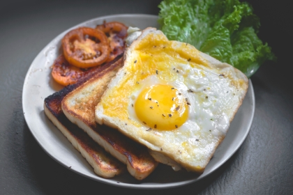 Egg on toast with tomato and lettuce on the side