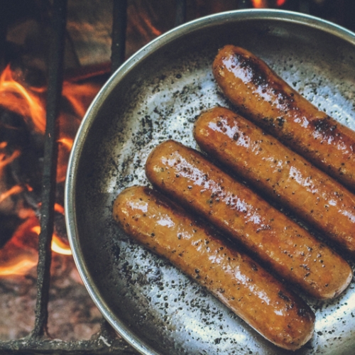 sausages sautéing over a fire