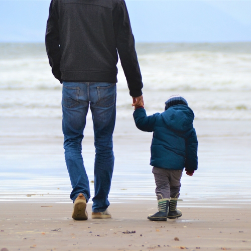 Father and son walking on the beach