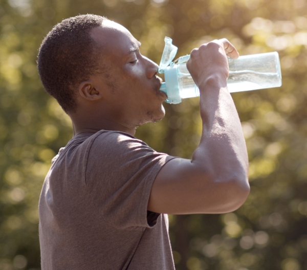 man drinking water from a reusable water bottle