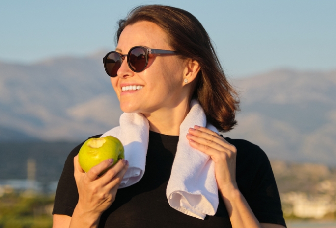 a woman on a hike eating an apple