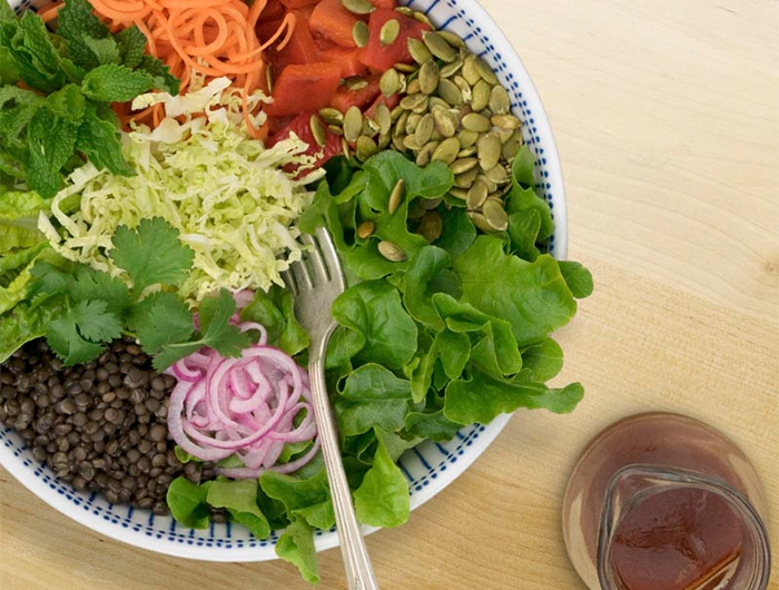bowl of salad with dressing on side