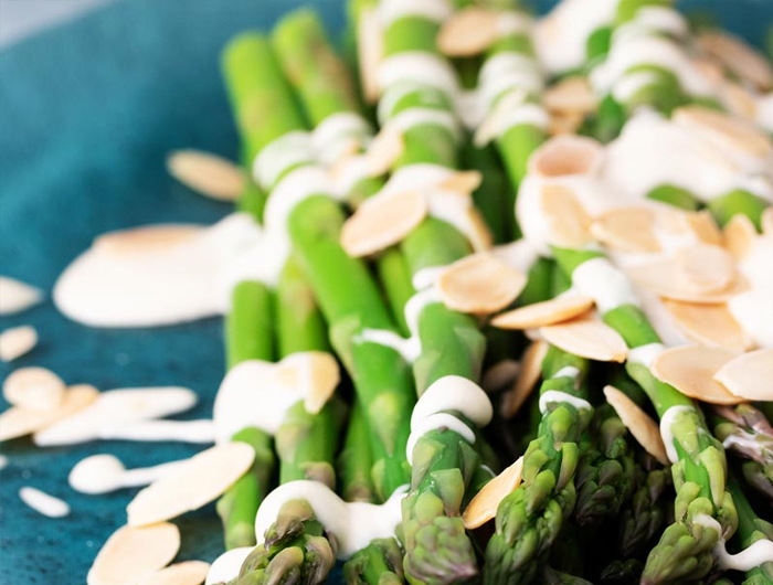 asparagus with almonds and sauce on plate