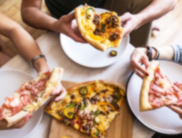 people eating pizza around table
