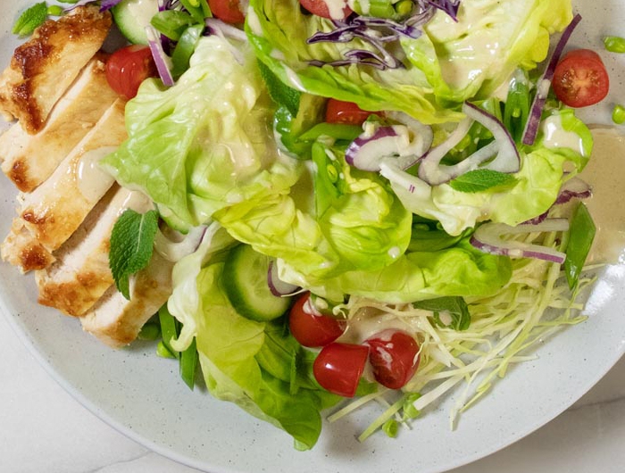 salad with greens, chicken, cucumber, and tomato