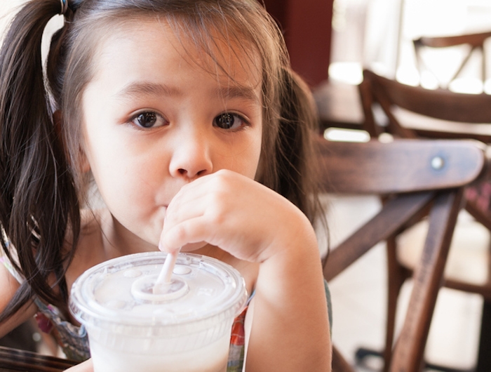 Child drinks soda from straw