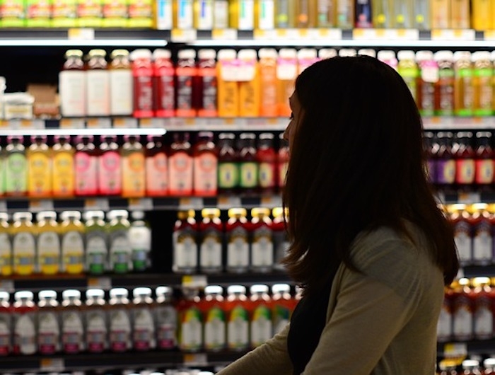 Woman browses beverages in grocery store aisle