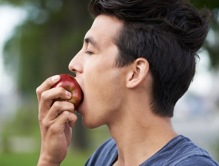 person biting an apple