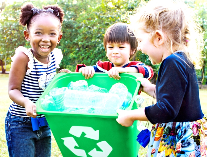 3 children carrying green recycle bin