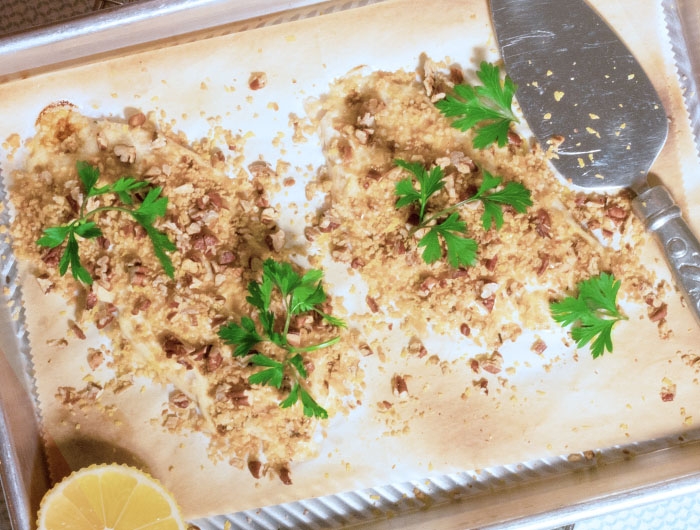 Tray with 2 filets of crunchy pecan tilapia with garnishes 