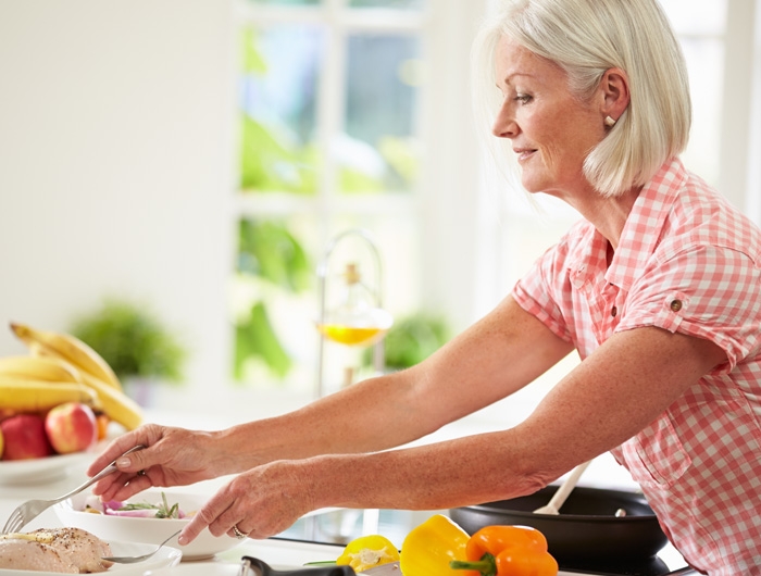 older woman prepping food in a kitchen