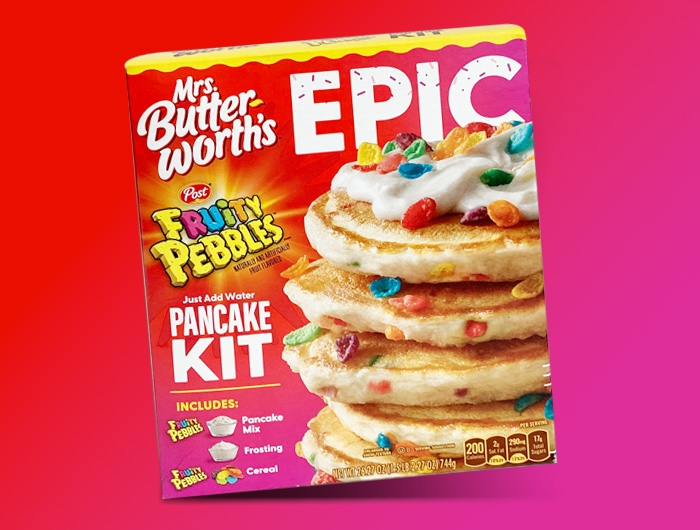 box of Epic Fruity Pebble pancake mix on red and pink background