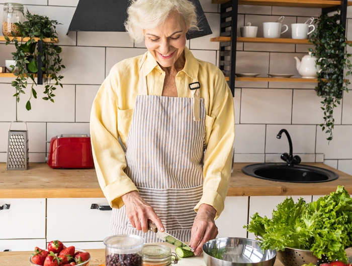 Older woman chopping vegetables in kitchen